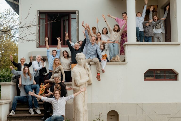 Grande photo de famille prise à domicile sur leur maison, capturant des moments joyeux et spontanés en extérieur à Lyon.