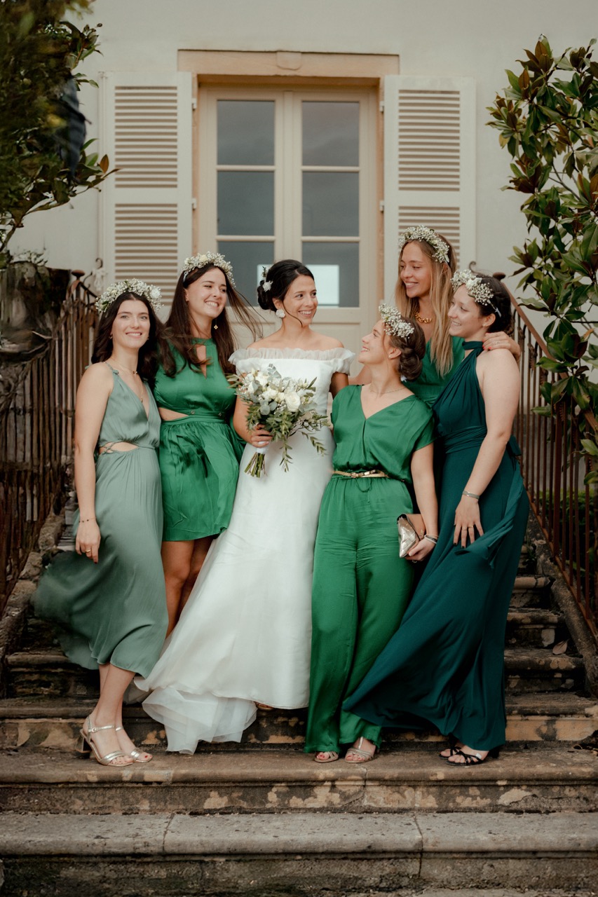 Mariée entourée de ses demoiselles d'honneur vêtues de vert, photo de mariage à Lyon sur les marches d'un château