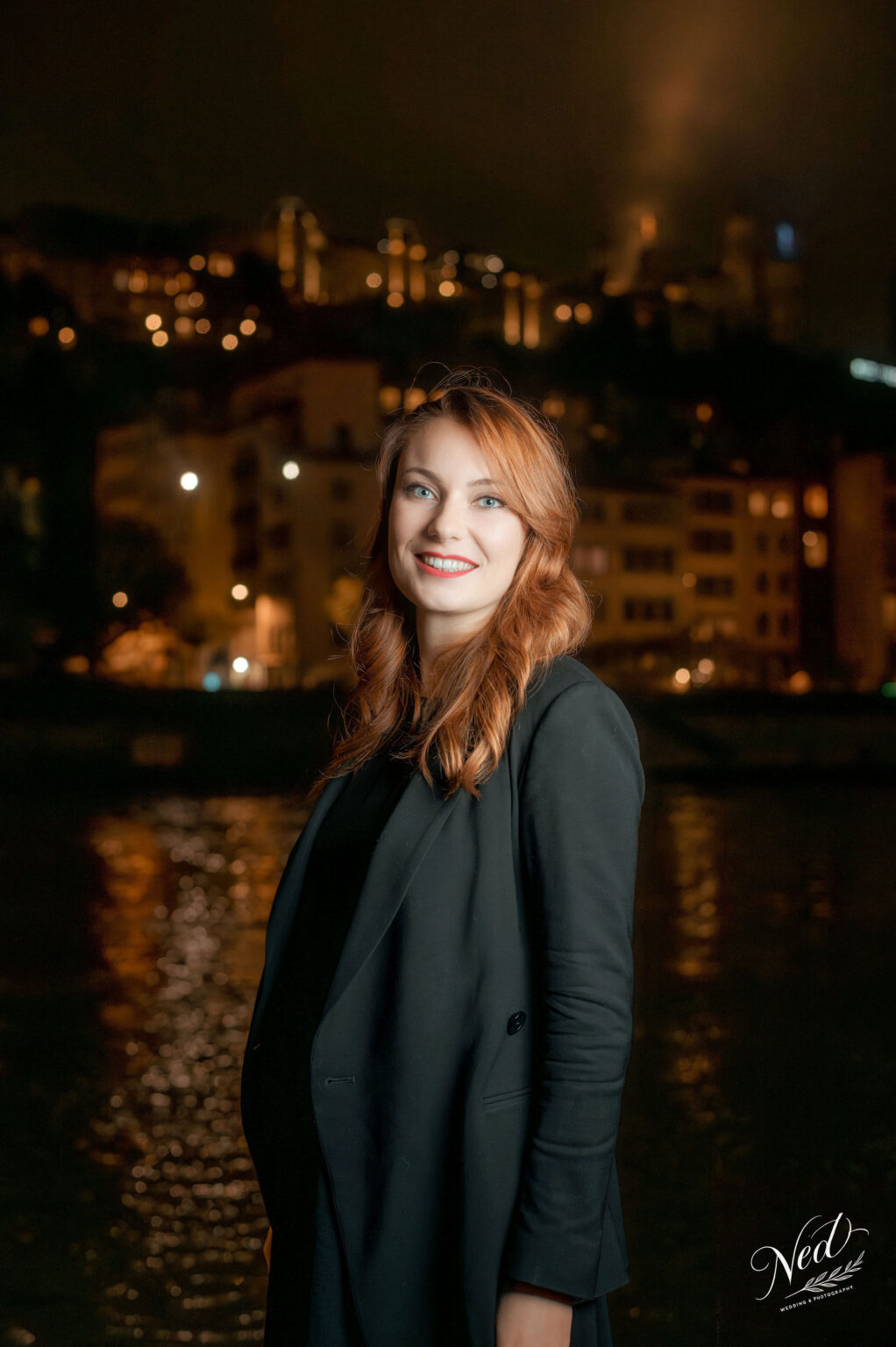 Femme rousse souriante en séance photo professionnelle de nuit avec éclairage déporté à Lyon