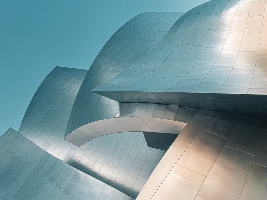 Photographie minimaliste de structure architecturale métallique aux courbes organiques style Jack Fleming contre ciel bleu