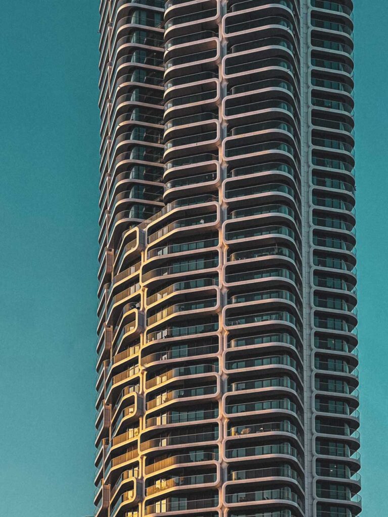 Fragment de tour moderne avec balcons courbes répétitifs photographié en contre-plongée style Jack Fleming architecture minimaliste