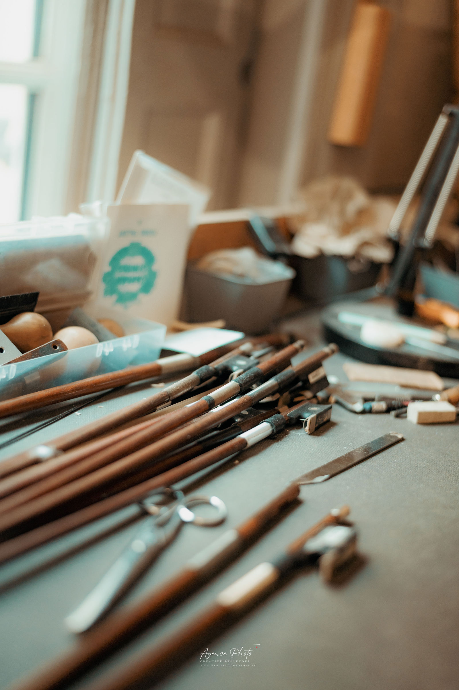 Pinceaux et outils de peinture alignes sur table grise, oeuf et conteneurs turquoise pres de fenetre