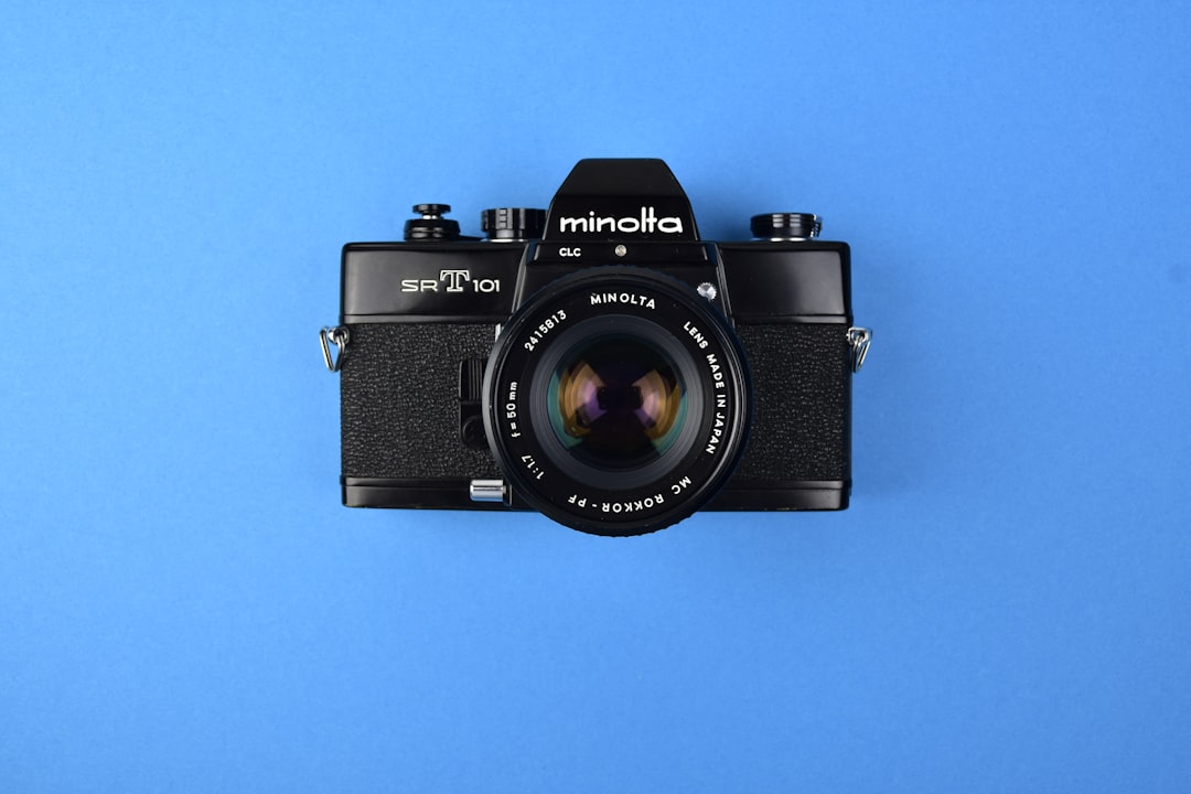 Minolta SRT 101, reflex argentique entièrement mécanique sur fond bleu