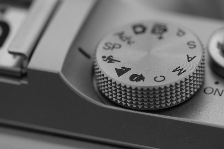 Detailed macro shot of a camera mode dial, showcasing settings in black and white.