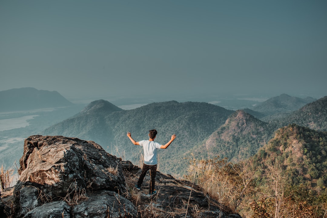 man standing on mountain cliff