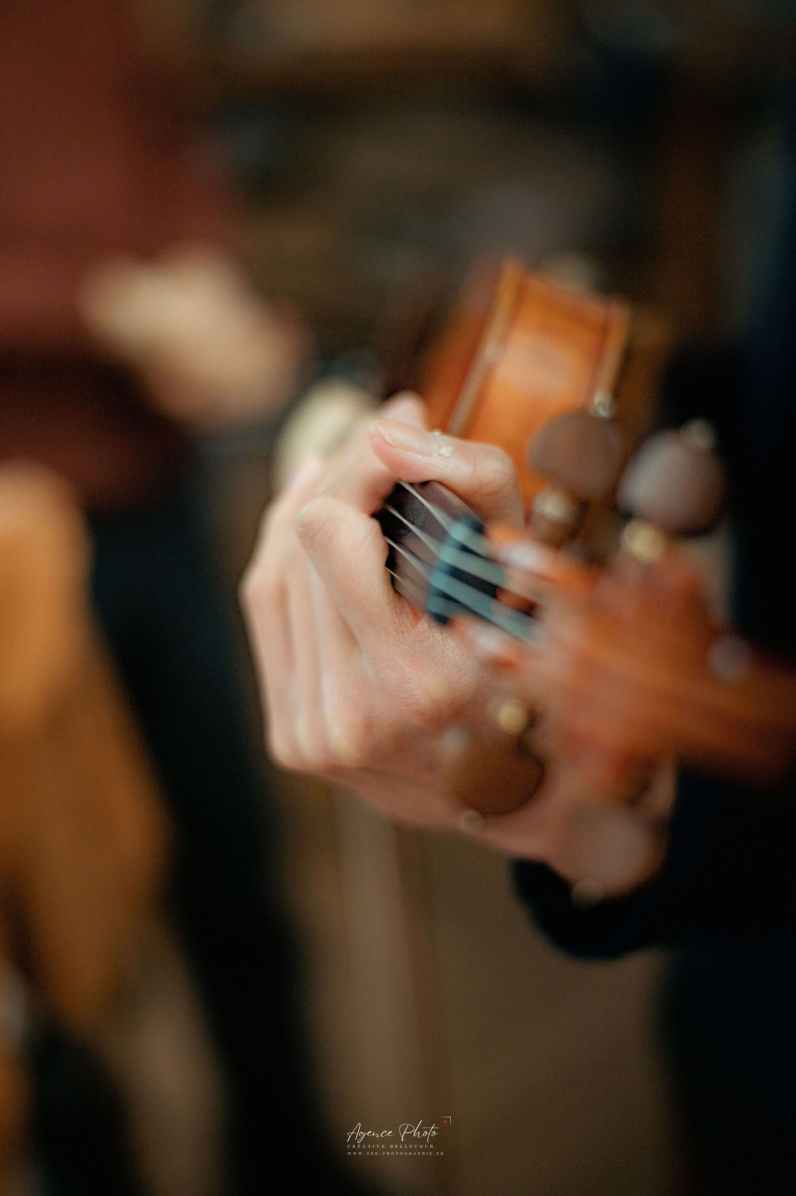 Mains de musicien jouant du violon, les doigts en action sur les cordes, fond flou