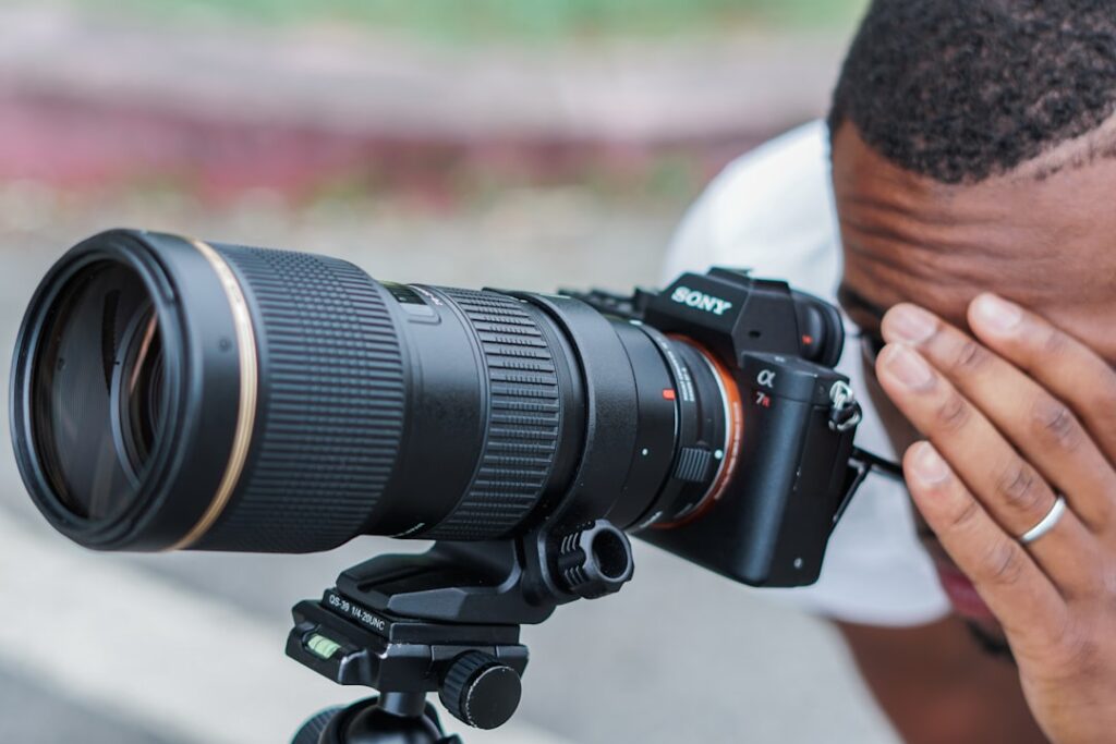Photographe vérifiant les réglages de son appareil reflex pendant un atelier