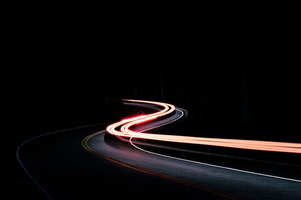Traînées lumineuses de voitures sur une route photographiée en pose longue