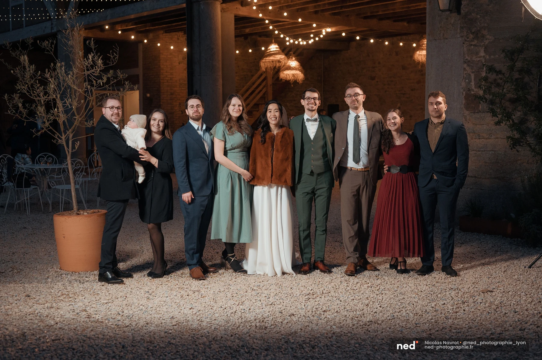 Groupe d'amis avec mariés en costume vert et robe blanche, soirée extérieure, mariage au Domaine de Tourieux