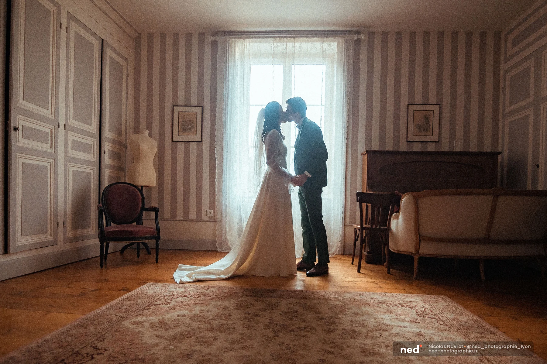 Mariés silhouette contre-jour fenêtre first look intérieur château robe traîne, mariage au Domaine de Tourieux