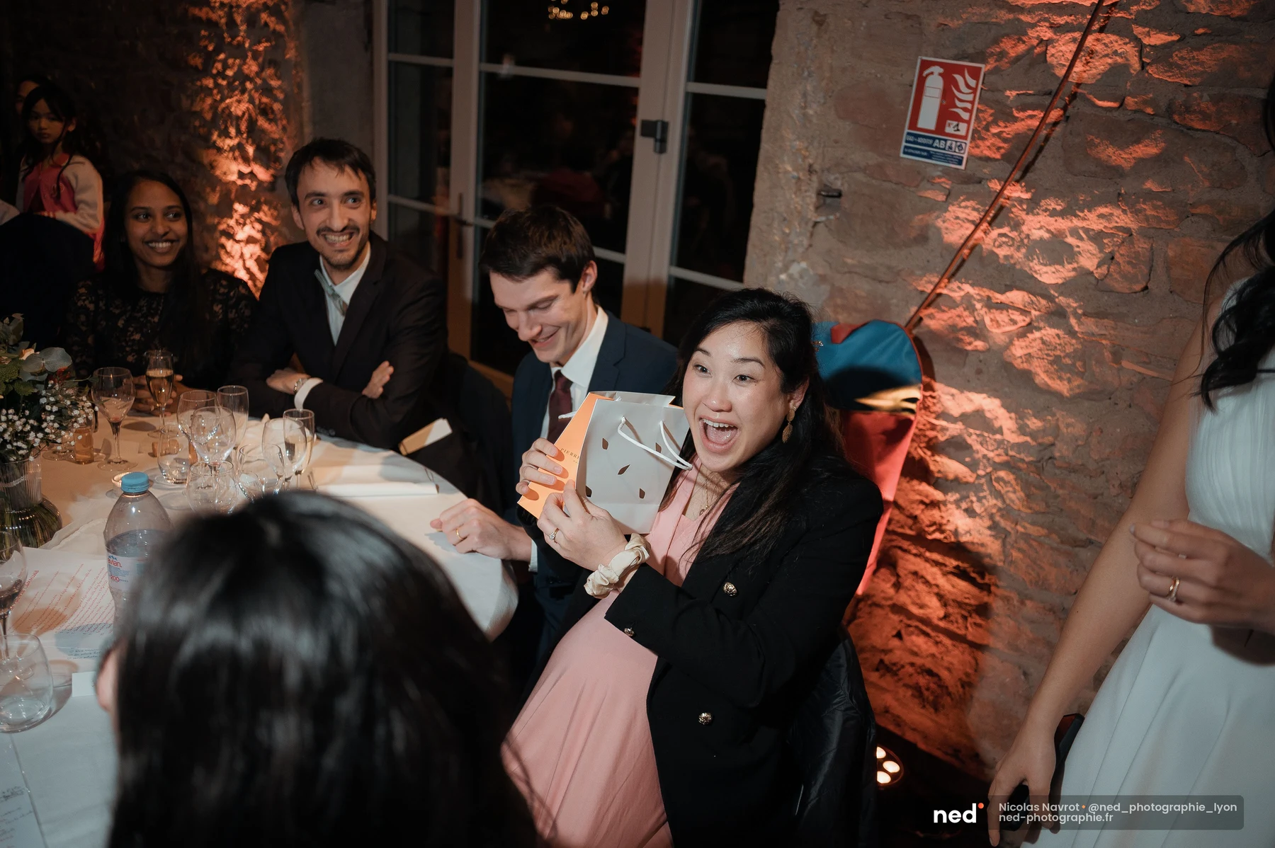 Invitée mariage riant tenant sac cadeau animation soirée salle pierre, mariage au Domaine de Tourieux