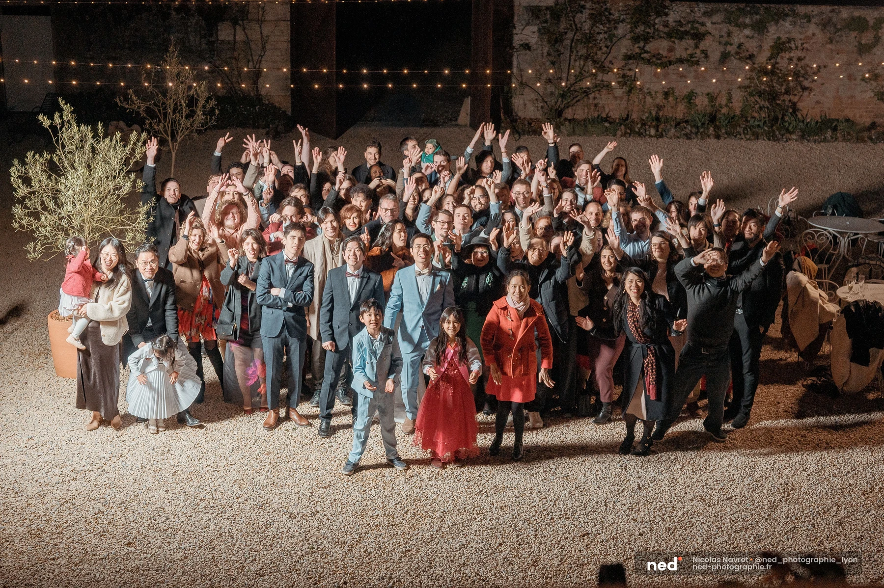 Photo de groupe mariage nuit cour pierre guirlandes convives bras levés, mariage au Domaine de Tourieux
