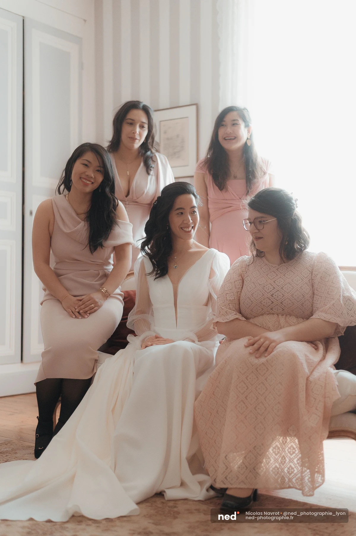 Mariée robe blanche entourée amies tons rose préparatifs mariage lumière naturelle, mariage au Domaine de Tourieux