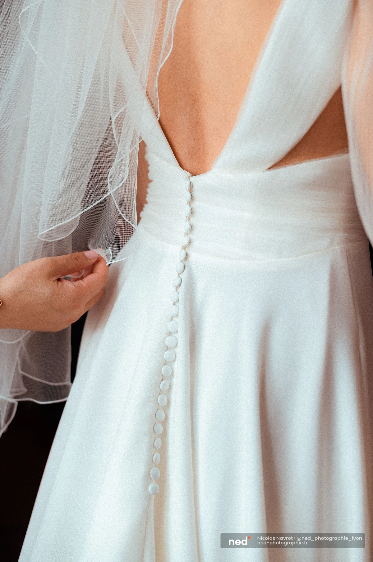 Dos robe mariée blanche boutons voile tulle préparatifs détail gros plan, mariage au Domaine de Tourieux