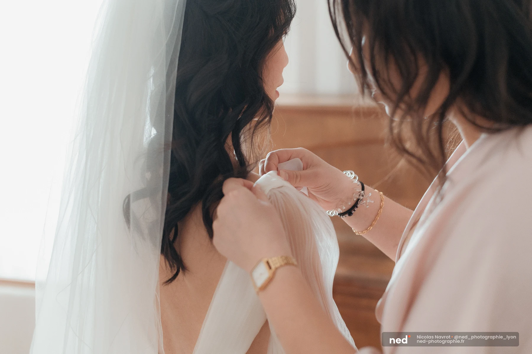 Proche ajustant le voile blanc de la mariée dans le dos, préparatifs mariage, mariage au Domaine de Tourieux