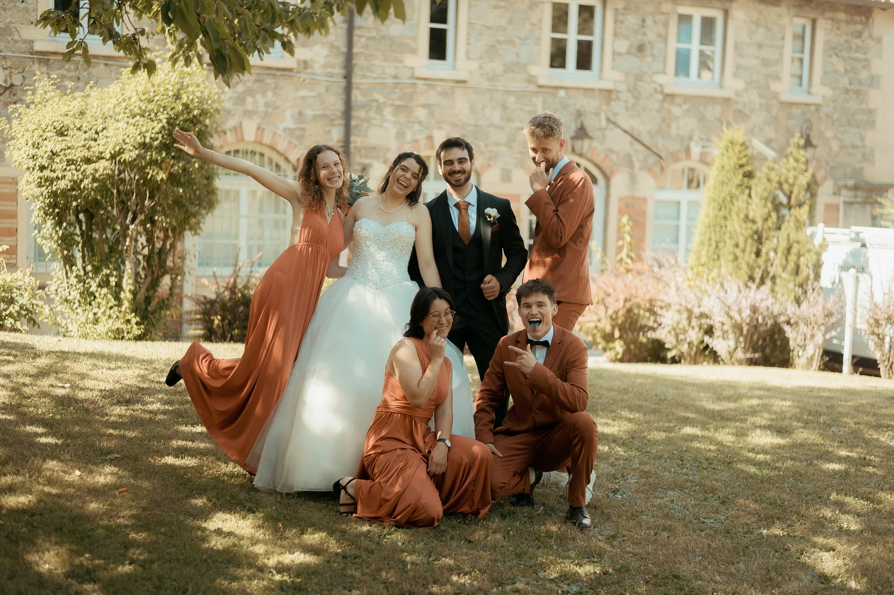 Groupe mariés et témoins en pose amusante et décalée dans jardin ensoleillé, mariage au Oullins-Pierre-Bénite