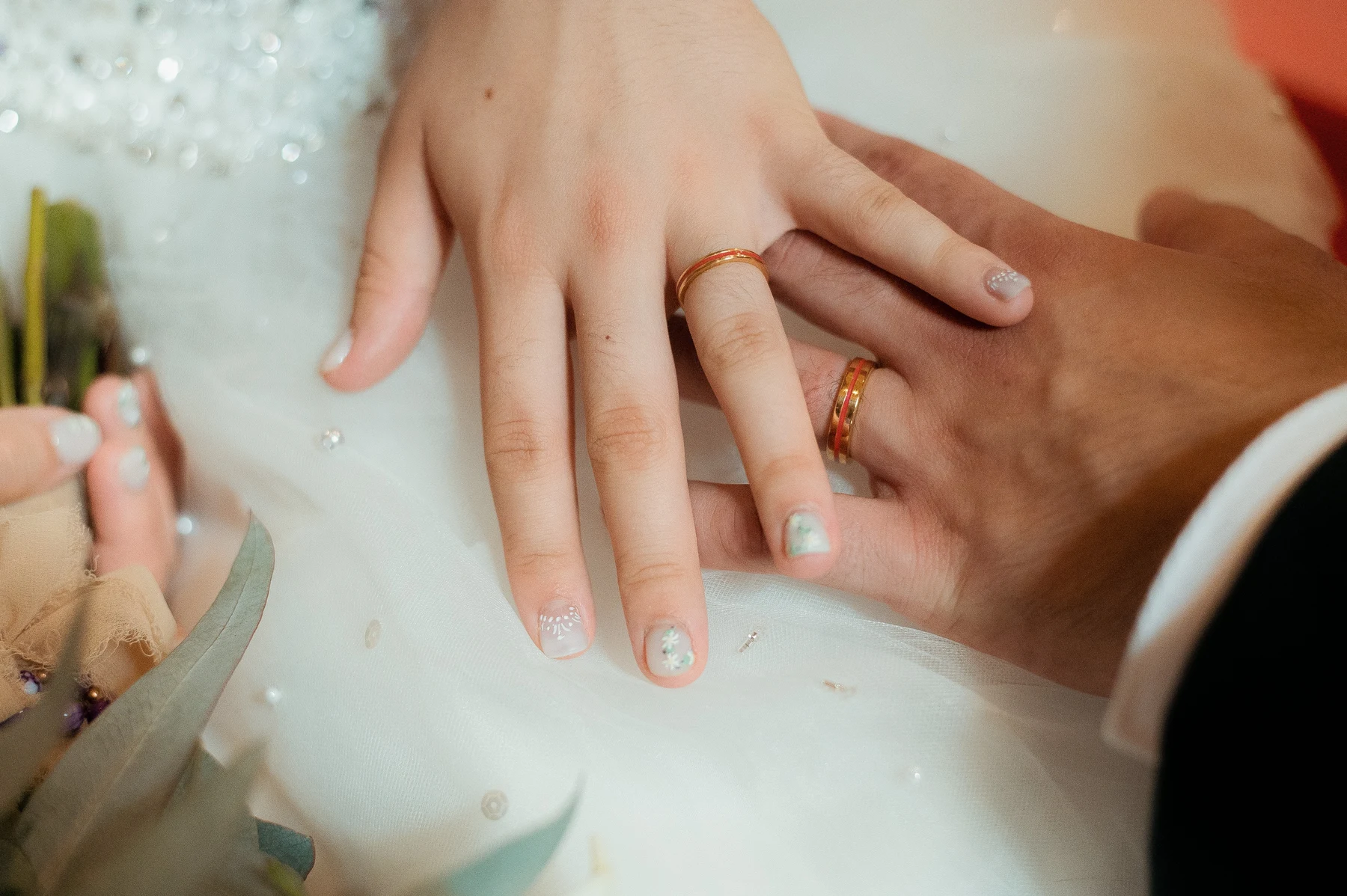 Gros plan de deux mains avec les alliances dorées après l'échange, mariage au Oullins-Pierre-Bénite