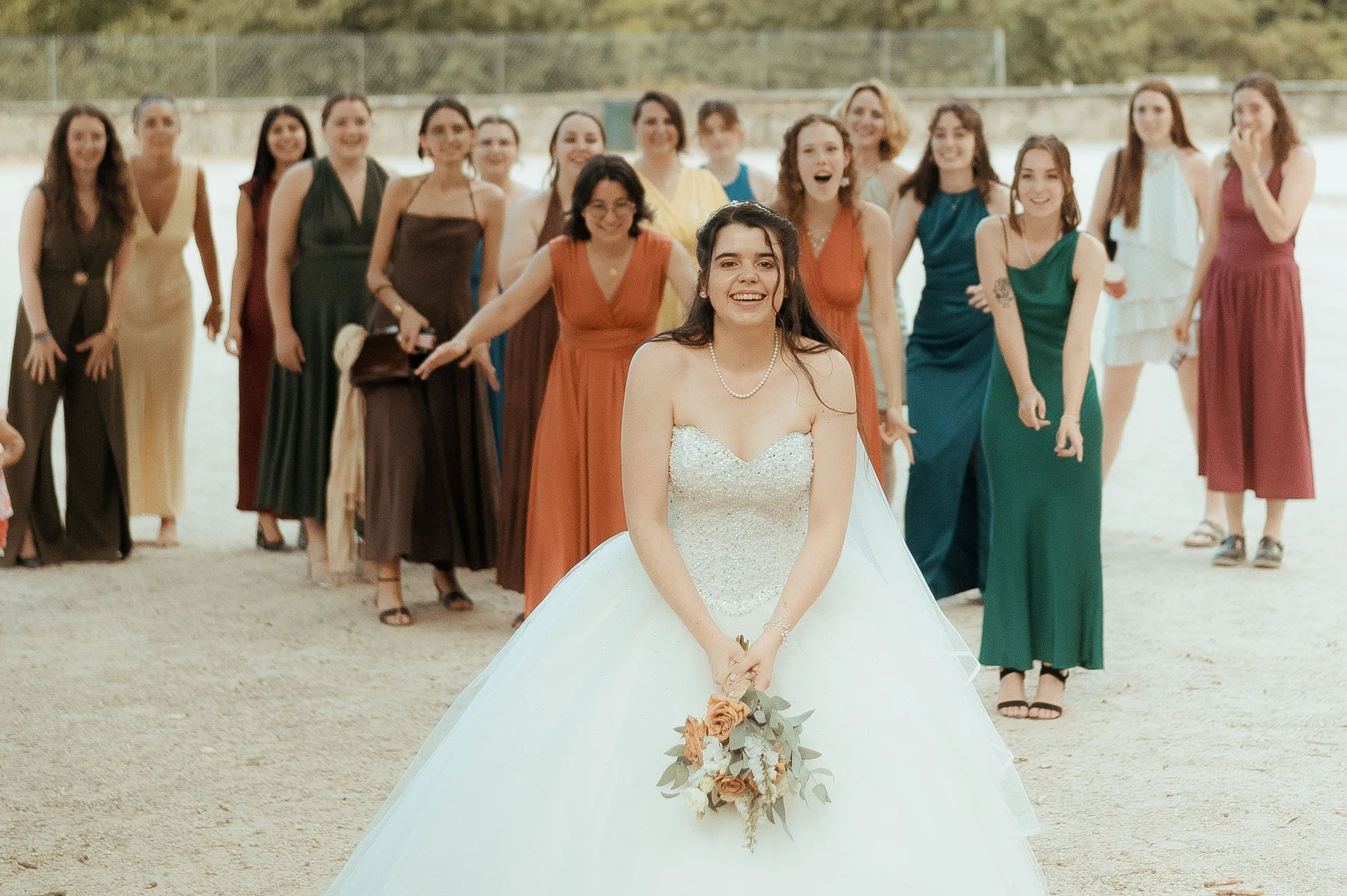Mariée dos aux invitées tenant son bouquet avant le lancer, extérieur, mariage au Oullins-Pierre-Bénite