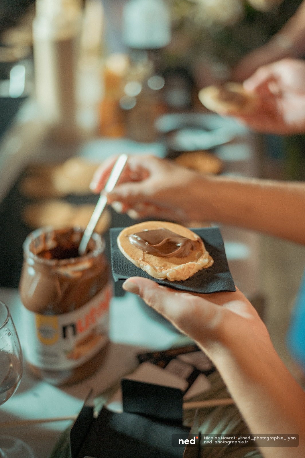 Groupe de personnes partage un moment autour de tartines au chocolat et d'un pot de pate a tartiner sur une table