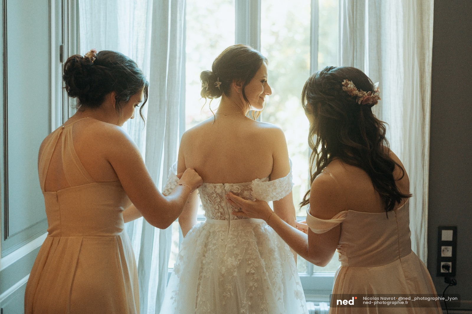 Mariée avec demoiselles d'honneur à la fenêtre