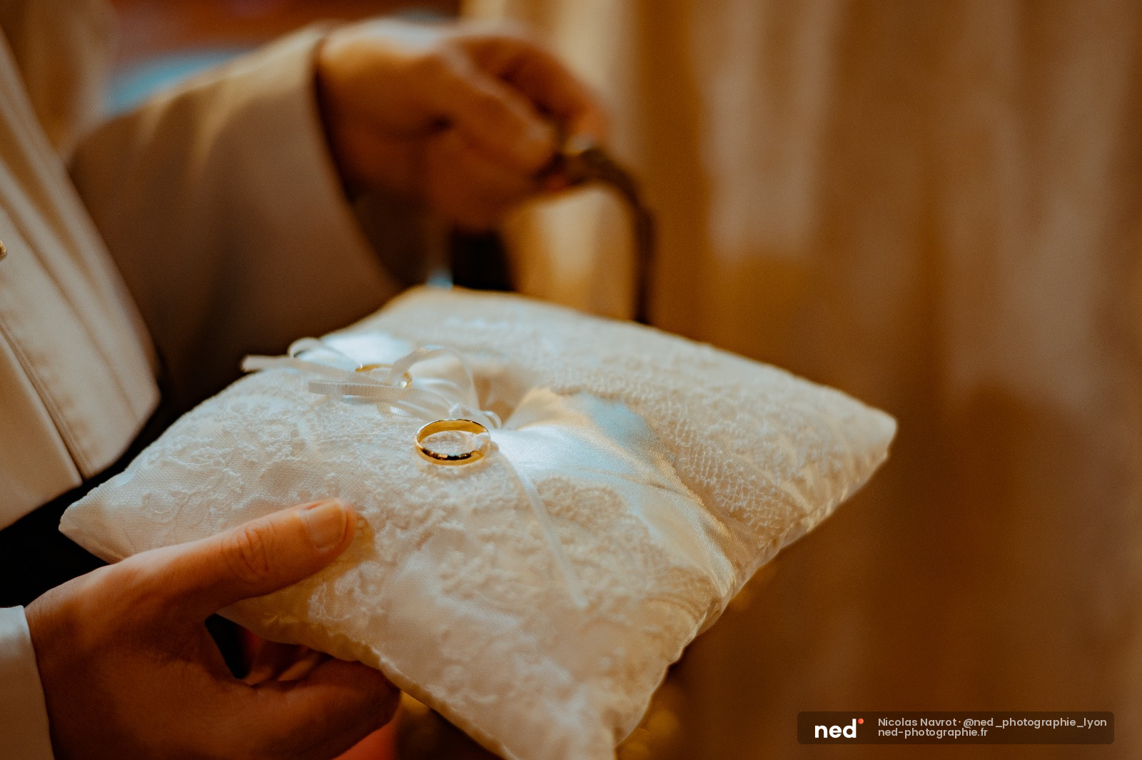 Main tenant un coussin en dentelle blanche avec alliance en or, ceremonie de mariage