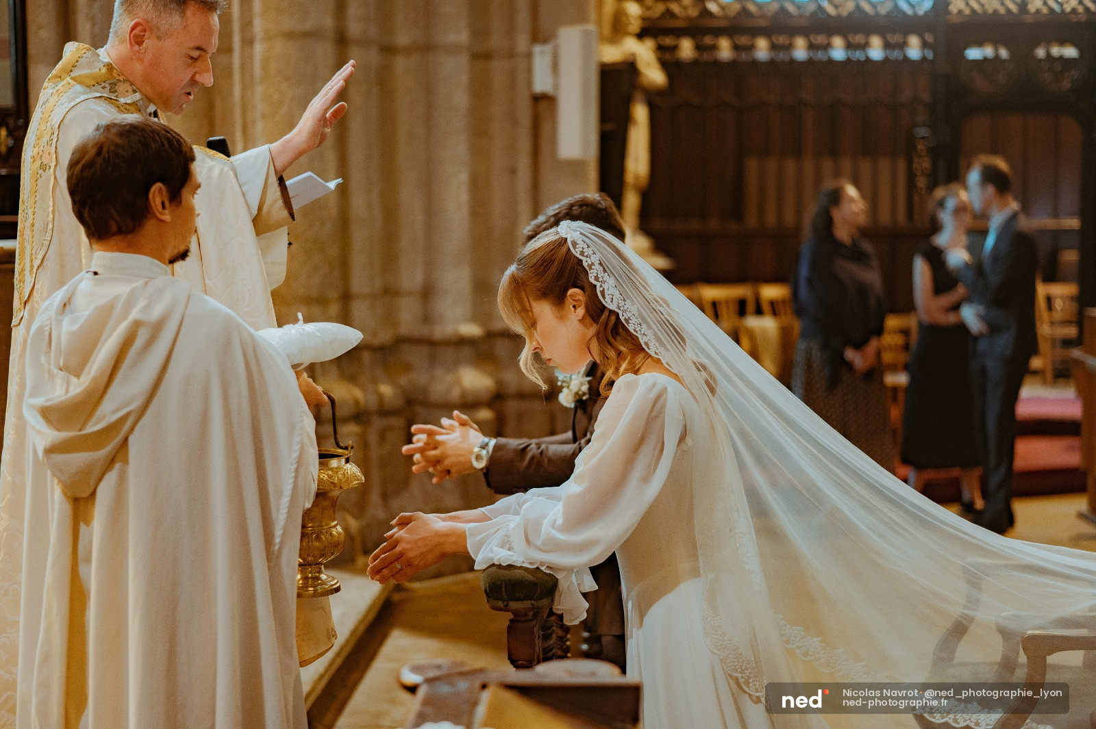 Mariée en robe blanche et voile devant l'autel avec le prêtre, lumière dorée de l'église