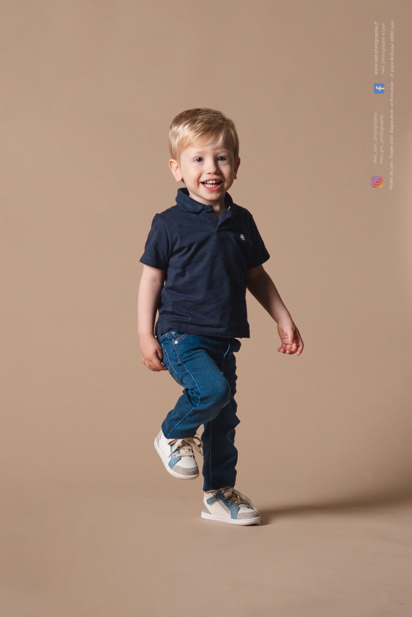 Jeune garçon en mouvement, rieur, lors d'un portrait en studio