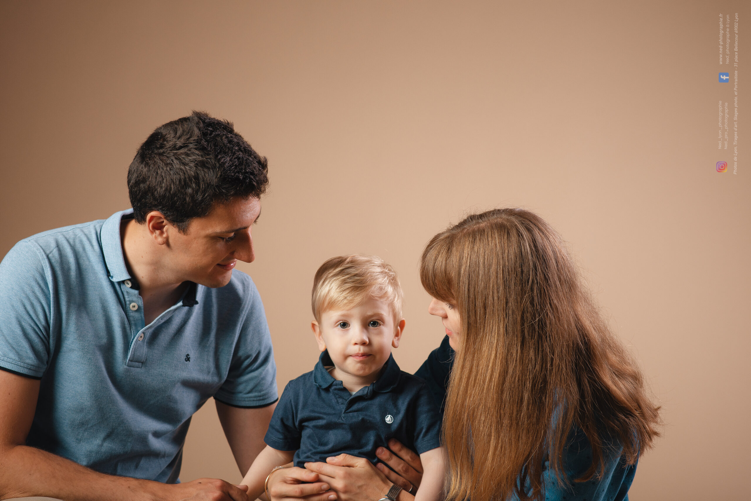 Les parents regardent leur jeune fils pendant une séance famille en studio